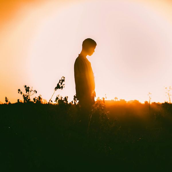 Person in a calm, meditative state outdoors at sunrise.